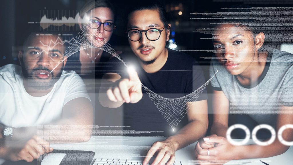 Shot of a group of businesspeople connecting to a user interface while working in an office at night
